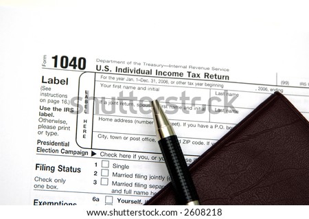 Filing a tax return. Pen and check book against the tax form