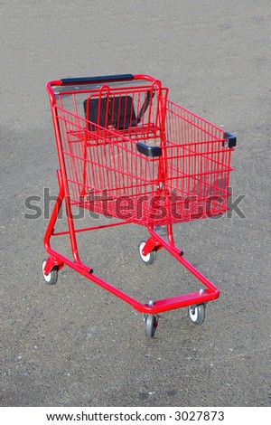 Red shopping cart isolated on a road