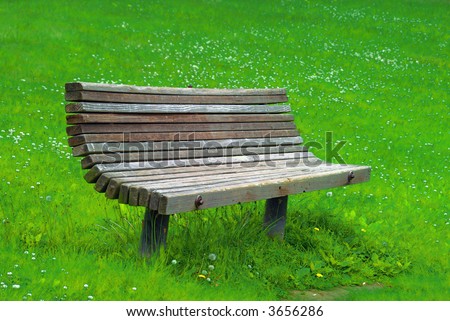 an old  park bench isolated on grass back ground