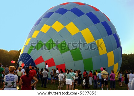 Recently landed hot air balloons and swarm of people watching it.