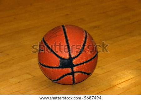 An old worn basketball on an indoor court