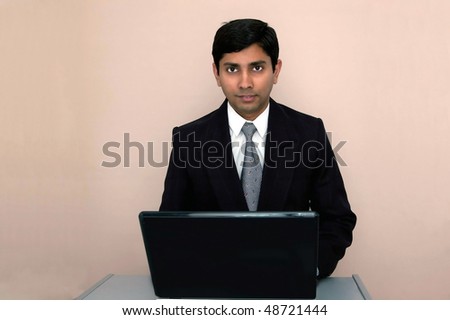 An handsome Indian businessman working on a laptop