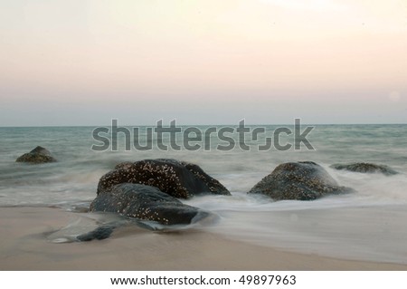Stormy waves hitting rock on a tropical beach