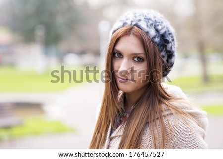 Portrait of attractive girl with bonnet in the park.