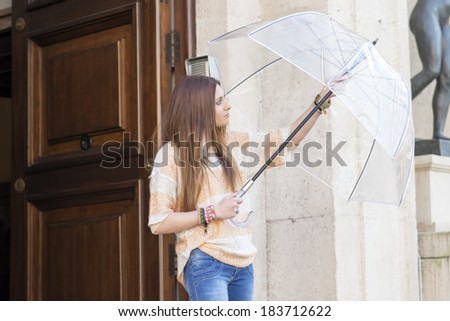 Young woman leaves the portal and open umbrella.