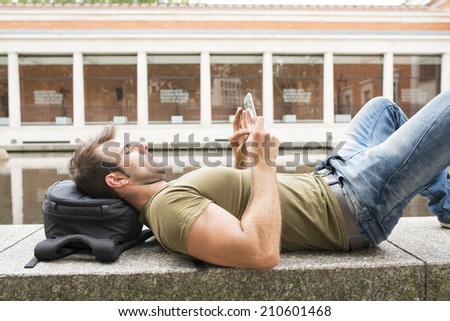 Man resting lying in the park and laptop tablet computer.