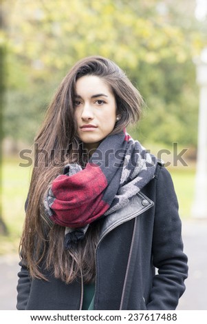 Beautiful young woman wearing scarf in the park.