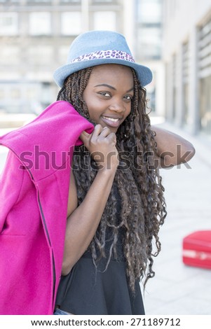 Portrait of beautiful smiling african young woman with hat urban style in the street.