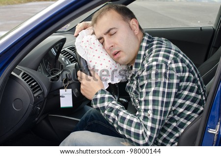 Exhausted man is sleeping in a car.