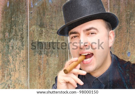 Man with hat and cigar, background and texture of wood.