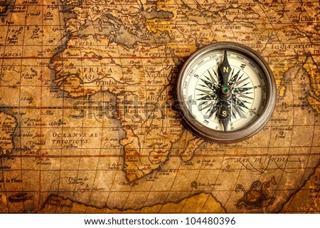 Old vintage retro compass on ancient map. The map used for background is in Public domain. Map source: Library of Congress. Country: Belgium Year: 1570. Author: Abraham Ortelius (1527-1598)