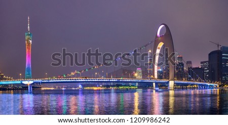 Guangzhou cityscape skyline with Canton Tower over the Pearl River illuminated in the evening panorama. Guangzhou, China.