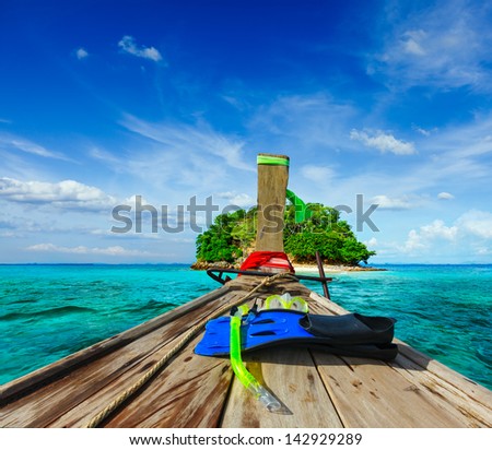 Vacation holidays adventure  concept background - tropical island and long-tail boat  with snorkeling set. Thailand