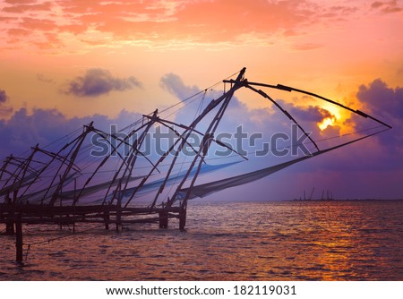 Vintage retro hipster style travel image of Kochi chinese fishnets on sunset with grunge texture overlaid. Fort Kochin, Kochi, Kerala, India