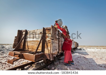 SAMBHAR, INDIA - NOVEMBER 19, 2012: Woman mining salt at lake Sambhar, Rajasthan, India. Sambhar Salt Lake is India\'s largest inland salt lake