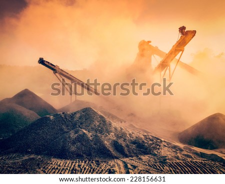 Vintage retro effect filtered hipster image of Industrial hell pollution background concept - crusher (stone crushing machine) at open pit mining processing plant for crushed stone sand and gravel