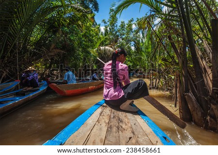 CAN THO,VIETNAM - 3 JUNE, 2011: Unidentified woman rowing on boat in Mekong river delta. Boats are common transport in Mekong delta