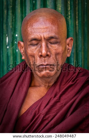 YANGON, MYANMAR - JANUARY 3, 2014: Portrait of ascetic Buddhist monk meditating in Shwedagon Paya pagoda