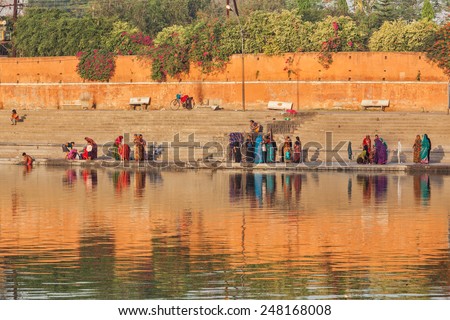 UJJAIN, INDIA - APRIL 25, 2011: People bathing and washing clothes in the morning on ghats of holy Kshipra river. Shipra is one of the sacred rivers in Hinduism