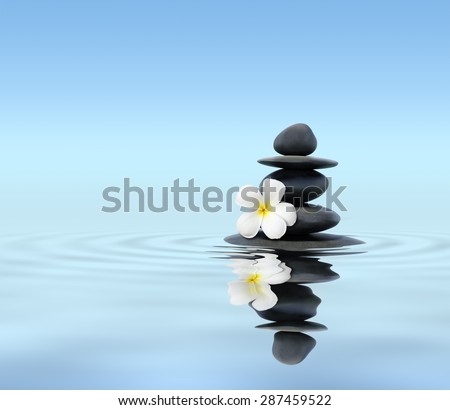 Zen spa concept background - Zen massage stones with frangipani plumeria flower in water reflection