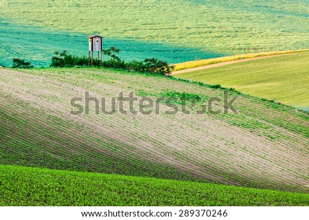 Rural Europe background - Moravian rolling landscape with hunting tower shack on sunset. Moravia, Czech Republic