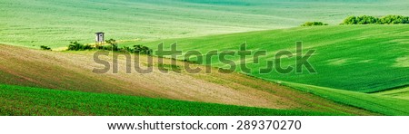 Panorama of Moravian rolling landscape with hunting tower shack on sunset. Moravia, Czech Republic