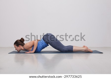 Beautiful sporty fit yogini woman practices yoga asana Ashtangasana - eight-limbed pose in studio