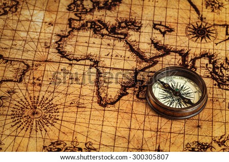 Travel geography navigation concept background - old vintage retro compass on ancient world map