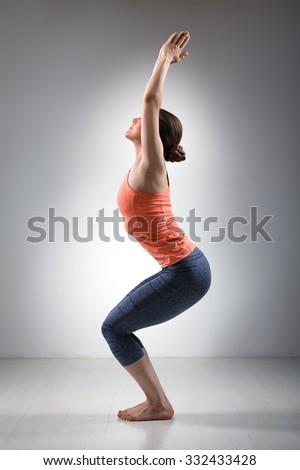 Sporty fit woman doing Surya Namaskar ashtanga vinyasa yoga asana Utkatasana - chair pose