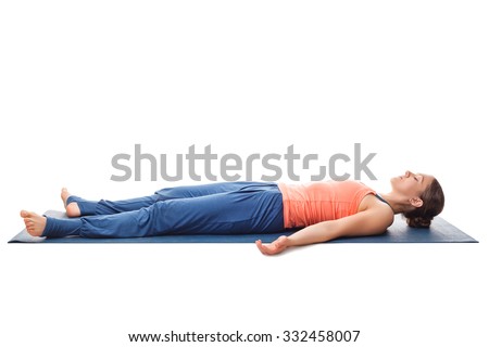 Beautiful sporty fit yogini woman relaxes in yoga asana Savasana - corpse pose isolated on white
