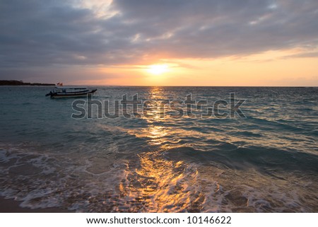 Calm ocean with boat during tropical sunrise