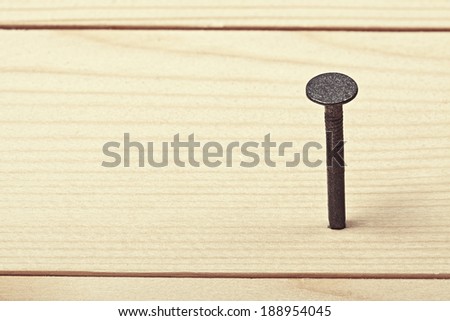 Nail in wood plank with space for text