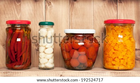 Preserved  vegetable on shelf near a brown wooden wall