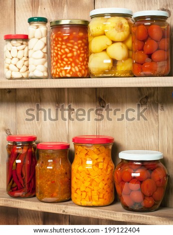 Preserved  vegetable on shelf near a brown wooden wall