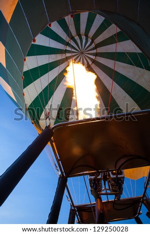 A hot air balloon fires to start up as it prepares to take tourist across the savannah. Serengeti National Park, Tanzania