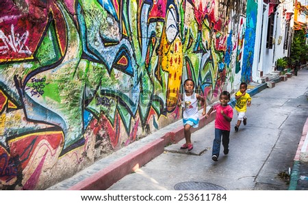 Cartagena, Colombia - February 23, 2014 - Local children run through the colorful streets of Cartagena\'s Getsemani neighborhood.