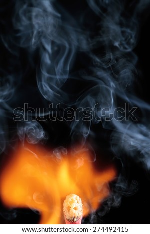 head of a matchstick between the flame and the smoke that draws a face like a ghost