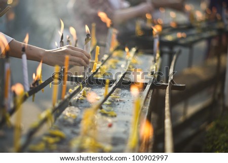 pray to buddha statue and candle in temple