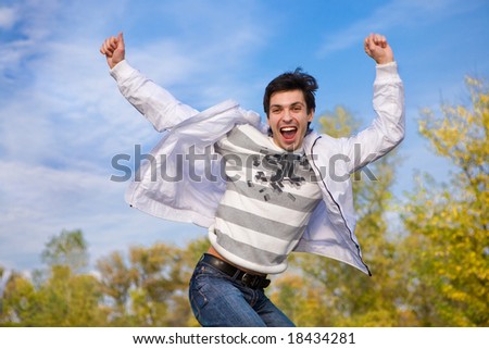 Happy young man jumps into air