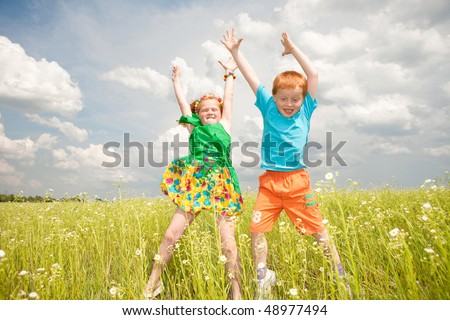 Two golden-haired children playin the field