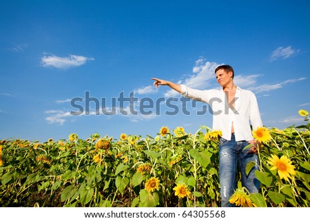 Happy young man shows the direction of hand