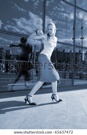 Young woman, blond, runs against the backdrop of the station