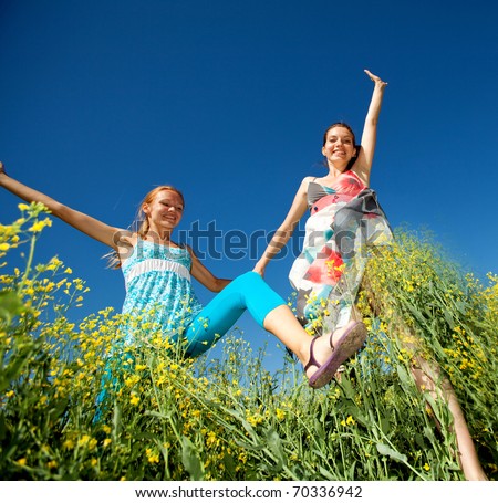 Happy people jumping in field