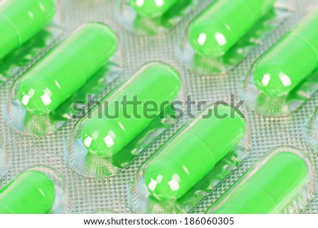 Macro bright green pills packed in transparent plastic package