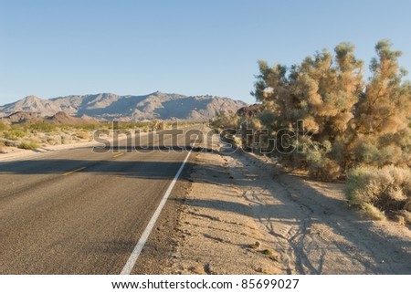 Deserted desert road stretching off to far away mountains.