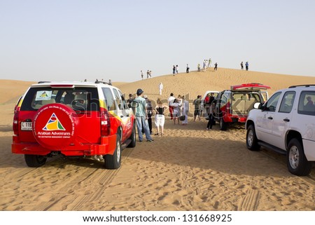DUBAI, UNITED ARAB EMIRATES - APRIL 18: Tourists making a tour in the middle of the desert of Dubai with Arabian Adventures jeeps on April 18, 2010 in Dubai, United Arab Emirates.