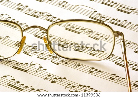A pair of glasses sitting on sheet music