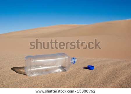 A empty water bottle in the middle of the desert