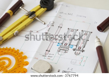 engineering drawing on drawing desk with rulers and pencils