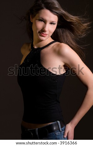 beautiful young woman in black shirt in front of a black background